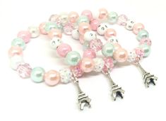 These adorable bracelets are the perfect favor for your little one's Paris themed party! Each bracelet features an antique silver Eiffel Tower charm, resin rhinestone beads and an assortment of pink, blue, peachy pink and white 10mm acrylic beads strung with durable stretch floss cord. Each bracelet will arrive individually packaged in organza bags. Please select the number of bracelets and bracelet size needed from the drop down menu. Please message me if you need a different amount of bracelet Whimsical Pink Bracelets For Birthday, Personalized Pink Whimsical Bracelet, Whimsical Personalized Pink Bracelet, Whimsical Pink Charm Bracelet For Birthday, Personalized Whimsical Pink Bracelet, Pink Themed Birthday Bracelets, Themed Pink Bracelets For Birthday, Cute Nickel-free Charm Bracelet For Birthday, Silver Novelty Charm Bracelet For Birthday