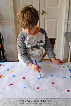 a young boy is making a paper map