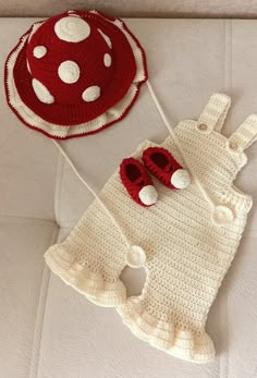 two crocheted items are laying on a bed with a hat and booties