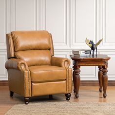 a brown recliner chair sitting next to a small table on top of a hard wood floor