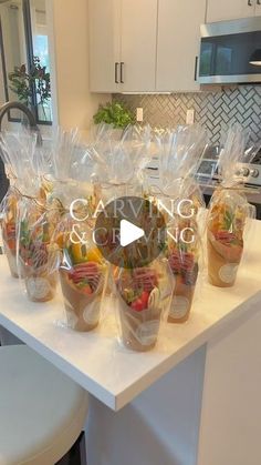 the kitchen counter is covered with plastic bags and cups filled with vegetables, fruits and veggies