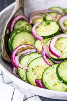 a white bowl filled with cucumbers and onions