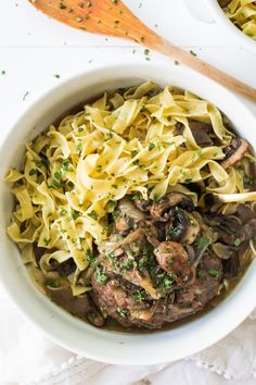 a white bowl filled with pasta and meat