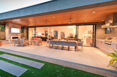 an outdoor kitchen and dining area are lit up at night