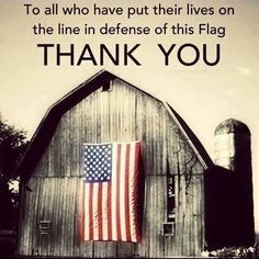 an american flag hanging on the side of a barn with a thank you message below