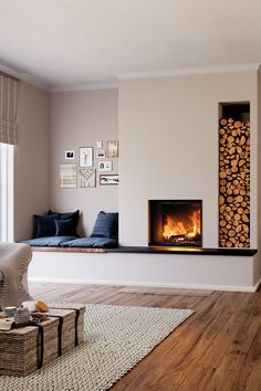 a living room filled with furniture and a fire place next to a window on top of a hard wood floor