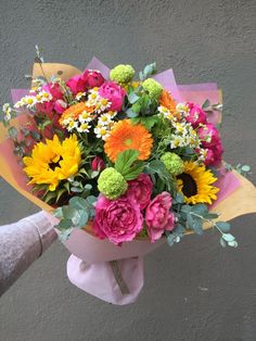 a person holding a bouquet of colorful flowers