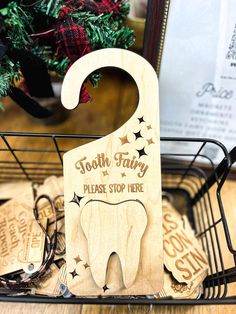 tooth fairy please stop here wooden sign on display in front of christmas tree and other decorations