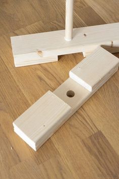 two pieces of wood sitting on top of a wooden floor next to a hole in the floor