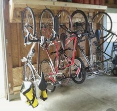 several bicycles are hanging on the wall in a garage with other bikes and equipment attached to it