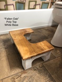 a wooden bench sitting in front of a bath tub next to a white toilet bowl