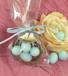 some eggs are sitting in a bag next to a flower and a bird's nest