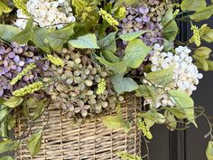 a basket filled with lots of flowers sitting on top of a door