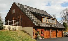 a large brown house with two garages and a car parked in front of it