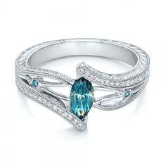 a ring with an aqua blue stone and diamonds on the sides, set in white gold