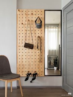 a room with a chair, mirror and hooks on the wall