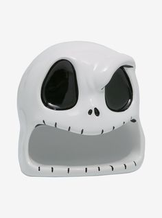 a white ceramic skull with black eyes and mouth