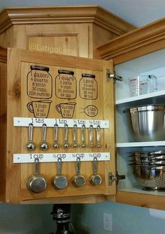 a kitchen cabinet with measuring cups and spoons on it