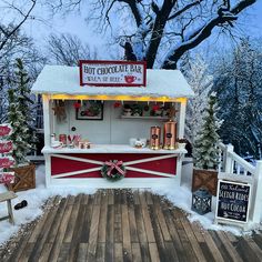 a hot chocolate bar is set up outside in the snow with christmas decorations on it