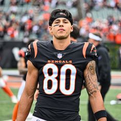 a football player is standing on the field in front of an orange and black crowd