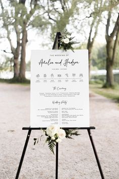 a welcome sign with flowers and greenery on it