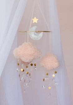 a baby mobile with stars and clouds hanging from it's side