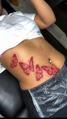 a woman sitting in a chair with her back turned to the camera and butterflies on her stomach