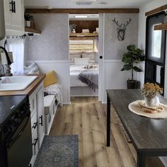 a kitchen and dining area in a small trailer or camper with wood flooring