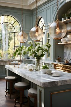 an elegant kitchen with marble counter tops and pendant lights hanging from the ceiling over the island