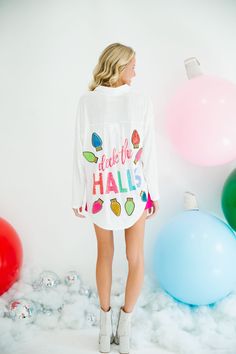 a woman standing in front of balloons with her back turned to the camera and wearing a white sweater