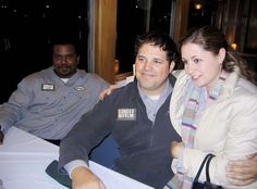 two men and a woman sitting at a table