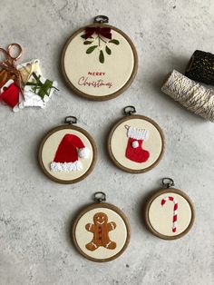 four embroidered christmas ornaments are displayed on a table