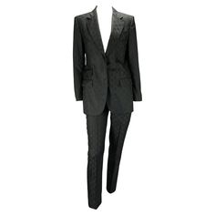 Presenting a rare Gucci black GG monogram pantsuit set, designed by Tom Ford. This woven GG print was prominently displayed on multiple looks during the Spring/Summer 1998 Gucci runway. The suit features hidden-button closures throughout and a discreet pocket on the front of the pants all designed to blend into the sleek and sexy tailoring that is classically Tom Ford. Approximate measurements: Jacket - IT40 29.5" shoulder to jacket hem 23.5" shoulder to cuff 17" armpit to cuff 38" bust 34" jack Gucci Luxury Notch Lapel Blazer, Luxury Full Length Gucci Pants, Luxury Black Pantsuit For Office, Luxury Tailored Black Pantsuit, Designer Black Sets For Workwear, Tom Ford Runway, Gucci By Tom Ford, Black Pantsuit, Suits Outfits