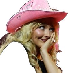 a woman with blonde hair wearing a pink cowboy hat and holding her hand to her face