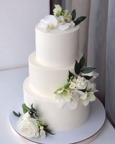 a three tiered cake with white flowers on top