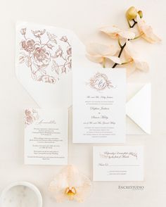 the wedding stationery is laid out with flowers