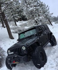 a black jeep is driving through the snow