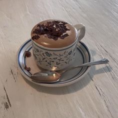 a cup of hot chocolate on a saucer with spoon