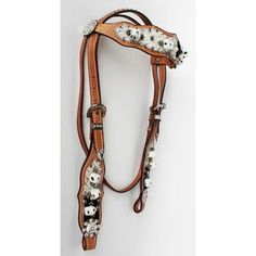 a horse bridle with white flowers and pearls on the side, sitting against a white background