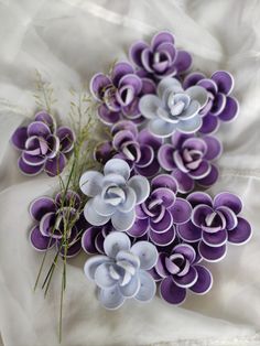 purple and white paper flowers on a white cloth