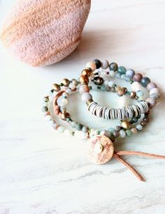 "First, at almost 22\" in length, this beaded strand can be worn as a necklace and a triple wrap bracelet if you like. Muted greens, grays, beige, gold, desert rose, touches of orange, rust, army green, beige, and more. A great mix of washed out color like a beaten ocean landscape. 6mm to 11mm Pearl, matte 4mm Moss Agate, matte Sunstone, matte 4mm  Jasper stones, and accents of seed beads, and metals. Distressed natural suede loops and coconut button closure make extendable. One-of-a-kind. The i Agate Bracelet With 108 Beads, Adjustable Jasper Jewelry For Healing, Adjustable Ocean Jasper Necklaces With Natural Stones, Bohemian Jewelry With Ocean Jasper Gemstone Beads, Adjustable Multi-strand Natural Stone Beads, Bohemian Ocean Jasper Gemstone Beads Jewelry, Adjustable Earthy Jasper Jewelry, Beaded Jasper Round Beads Jewelry, Adjustable Beaded Agate Jewelry