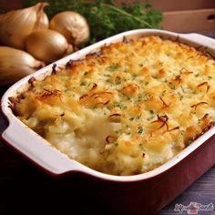 a casserole dish with potatoes and parmesan cheese on the side next to onions