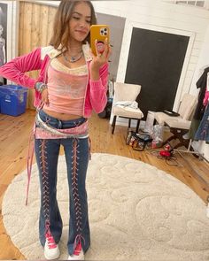 a young woman is taking a selfie with her cell phone while standing on a rug