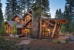 a large log home surrounded by trees and rocks