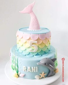 a birthday cake with a dolphin and fish decoration on the top, sitting on a plate