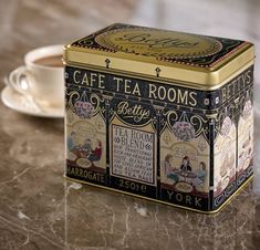 a tea box sitting on top of a table next to a cup and saucer