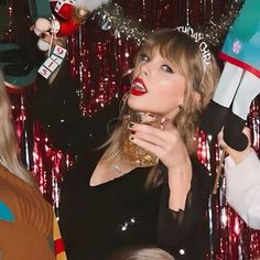 the woman is holding up her hairbrushes in front of two other women wearing christmas hats