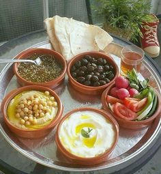 an assortment of different foods on a plate with sauces and condiments in bowls