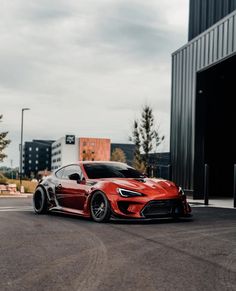 a red sports car parked in front of a building