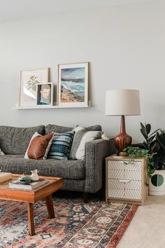 a living room filled with furniture and pictures on the wall above it's coffee table